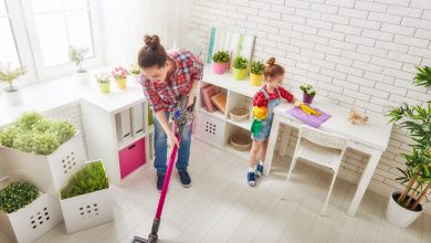 Frau staubsaugt in Wohnung